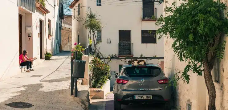 black sedan parked beside white concrete building during daytime