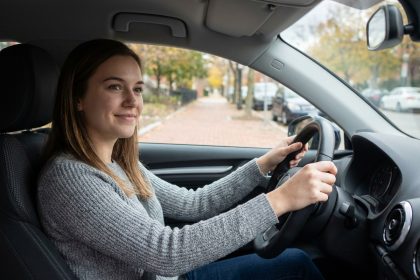 Jeune femme confiante au volant d'une voiture en ville