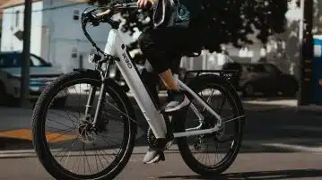 man in black jacket riding on white and black bicycle