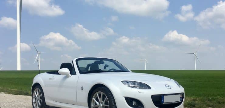 white porsche 911 on green grass field under blue sky during daytime